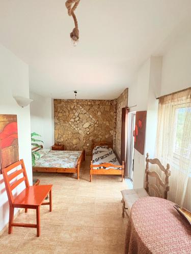 a room with two beds and a table and chairs at Villa w Studio, Pool, Garden, Sleeps 12 to 15 in Rákhai