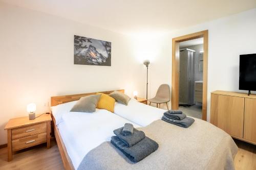a bedroom with two beds with towels on them at Studio Omis in Zermatt