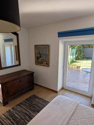 a bedroom with a mirror and a door to a patio at Casa da Mata in Paredes de Coura