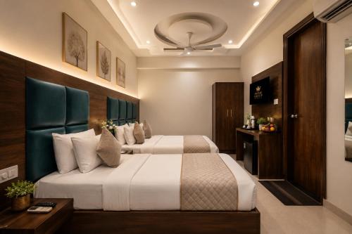 a hotel room with two beds and a table at Hotel Marina Premium Near IGI Airport Delhi in New Delhi