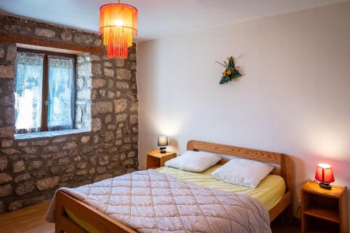 a bedroom with a bed and two lamps and a window at gite les ducs in Mialanes
