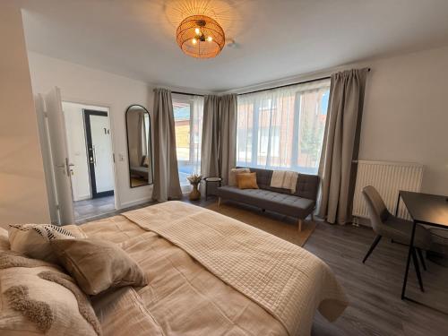 a bedroom with a bed and a table and a couch at Urban Nest Burg - Design Apartment mit Smart-TV, Self Check-in & Free Parking in Burg