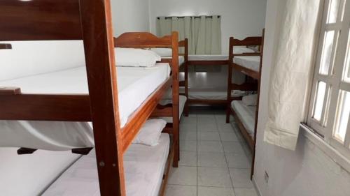 a room with several bunk beds and a window at Encantos do Mar Hostel in Recife