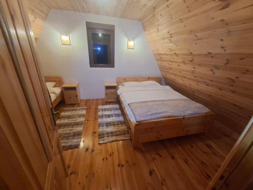 a bedroom with a bed in a room with wooden floors at Chalet Čilac in Žabljak