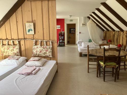 a room with two beds and a table and a dining room at Gîte Béthel in Lachamp-Raphaël