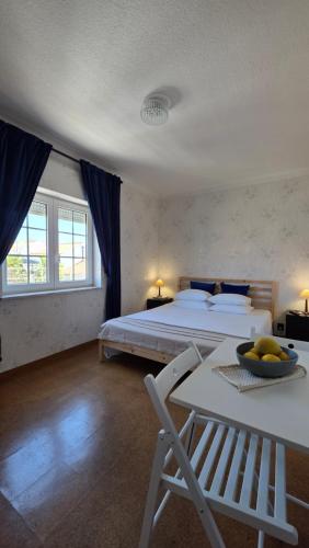 a bedroom with a bed and a table and a chair at Soleil Bleu in Vila Nova de Milfontes