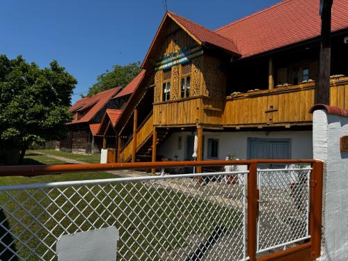 a wooden house with a fence in front of it at Čardak Mraclin in Mraclin