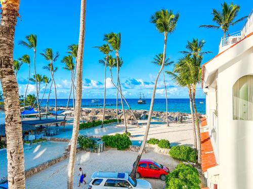 a view of a beach with palm trees and cars at FIESTA LOS CORALES - VILLAS and SUITES in Punta Cana