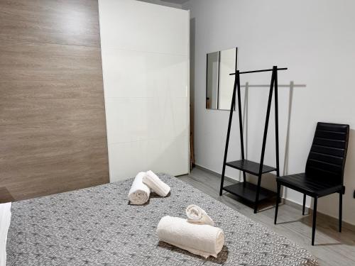 a room with two towels and a black chair at Luxury Sofi in Giardini Naxos