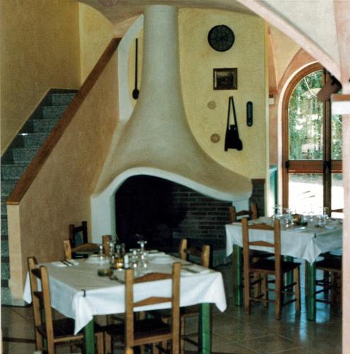 a dining room with tables and chairs and a staircase at Sant Efisio in Lotzorai