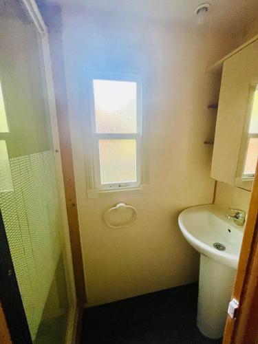 a bathroom with a toilet and a sink and a window at Flower Camping La Pibola in Camon