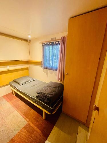 a bedroom with a bed in a room with a window at Flower Camping La Pibola in Camon