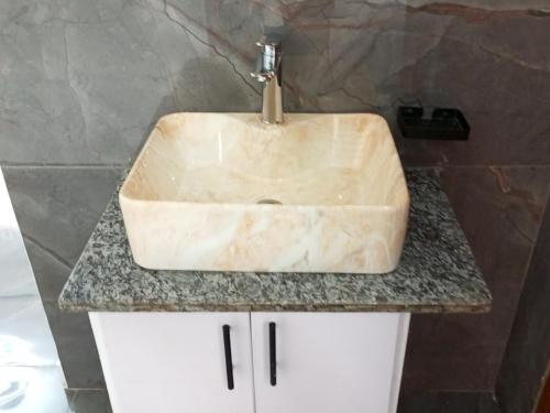 a sink with a faucet on top of a counter at Peaceful Home in Kigali