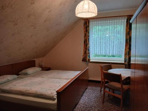 a bedroom with a bed and a table and a window at Haus am Kirschbaum in Belum