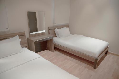 Habitación pequeña con 2 camas y espejo. en Rafa Homes Al Izdihar 2 en Riad