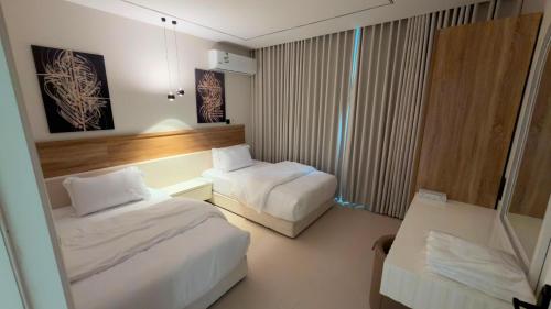 a hotel room with two beds and a table at Modern 2BR Apartment in Khafji in Khafji