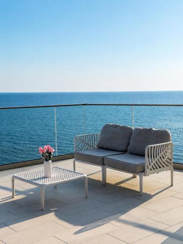 a couch and a table on a balcony with the ocean at Villa La Reina in Bar