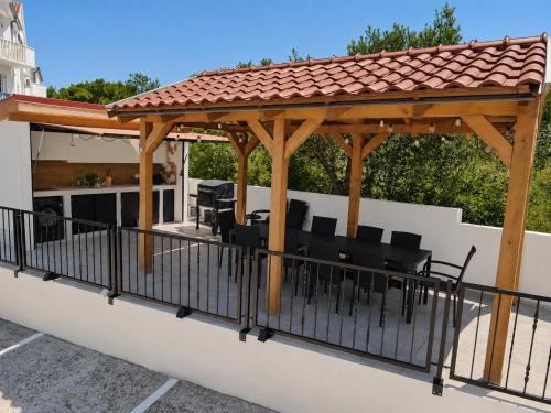 a pergola on a patio with black furniture at The Good Place in Sutivan