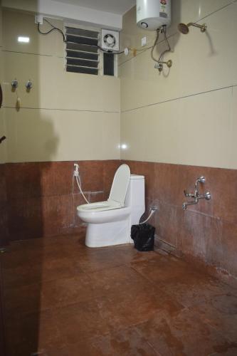 a bathroom with a white toilet and a shower at Sri Darshini Comfort Hinkal Mysore in Vānivilāsa Puram