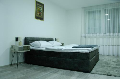 a bed sitting in a room with a window at Apartman Crvenka stan na dan in Crvenka