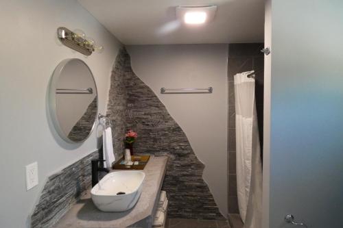 a bathroom with a sink and a stone wall at Aquastar Inn in Westerly