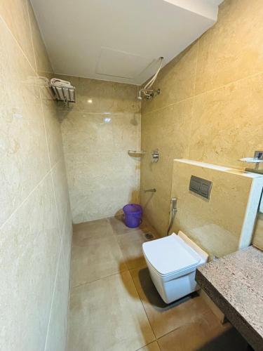 a bathroom with a white toilet in a room at Capital Suites in Bangalore