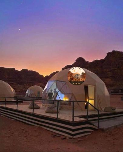 a group of three domes in the desert at sunset at camp sand in Disah