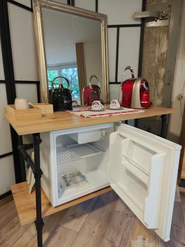 a table with an open refrigerator with a mirror at O&D Guest Room in Flurlingen