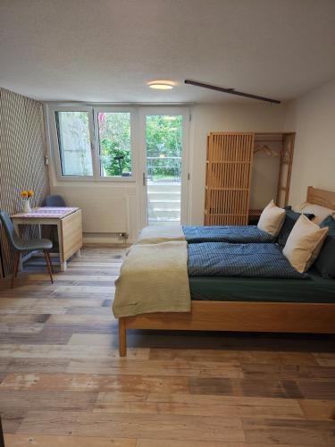 a bedroom with a large bed and a desk at O&D Guest Room in Flurlingen