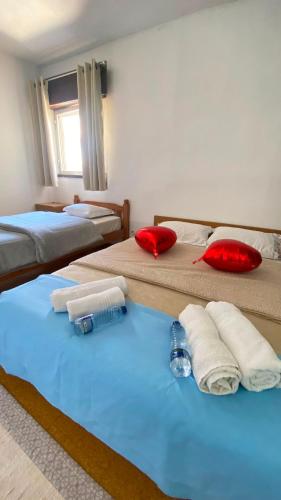 two beds in a room with towels and water bottles at Daboussi Home in Apúlia