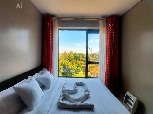 a bedroom with a bed with a large window at Reinastays in Kiambu