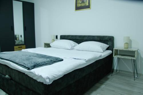 a bed with white sheets and pillows in a bedroom at Apartman Crvenka bazen in Crvenka
