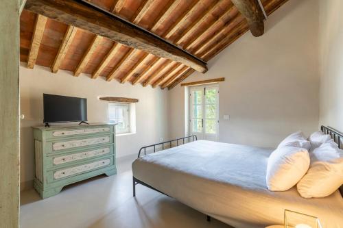 a bedroom with a bed and a dresser with a television at Relais Tosca in Cortona