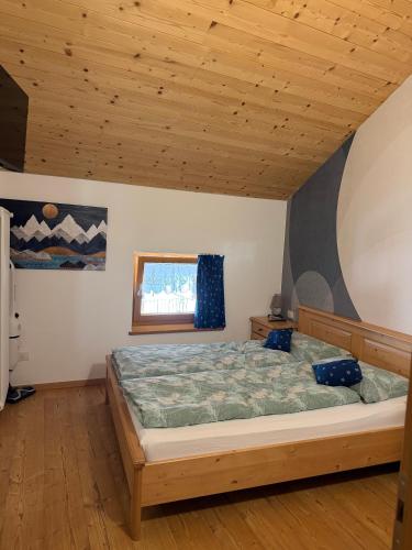 a bedroom with a bed and a wooden ceiling at Casa Seler - Appartamento verde in Predazzo