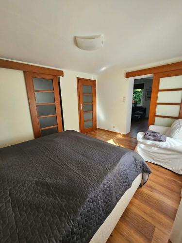 a bedroom with a large bed and wooden floors at Oaza Spokoju in Gdynia
