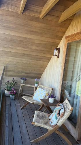 a wooden porch with two chairs and a table at B&B Les Trois Pignons in Diksmuide