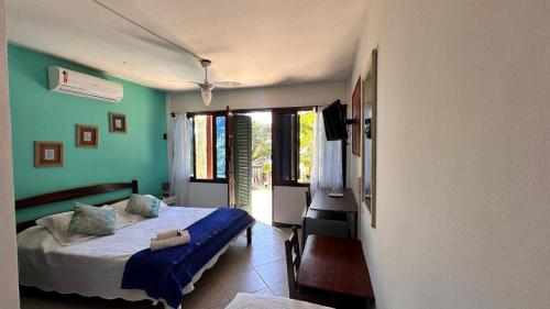 a bedroom with a bed in a room with green walls at Pousada Oceanica Buzios in Búzios