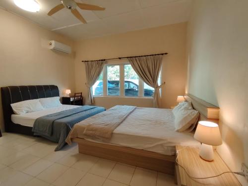 a bedroom with a bed and a window at Melaka Beach Villa C Type in Malacca