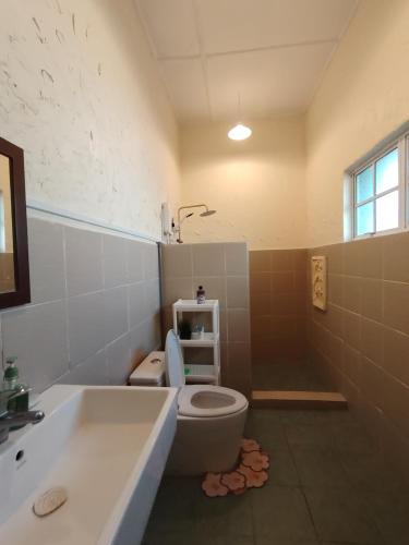 a bathroom with a toilet and a sink and a tub at Melaka Beach Villa C Type in Malacca