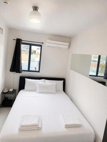 a bedroom with two beds with white sheets and a window at Hobart city hotel in Hobart