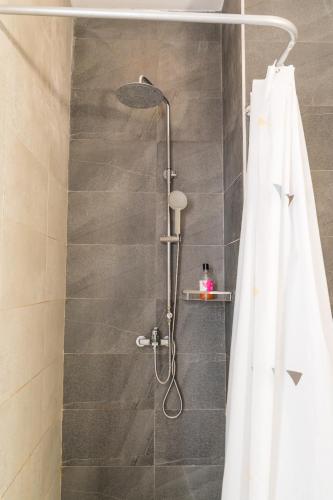 a shower with a white shower curtain in a bathroom at Le Marin, Rodrigues Island in Rodrigues Island