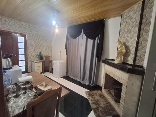 a living room with a table and a fireplace at Casa da Dôdi in São Joaquim