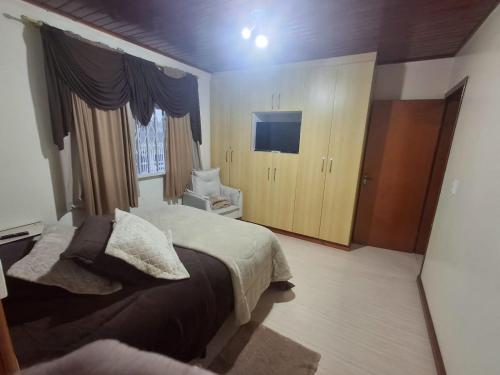 a bedroom with a bed and a television in it at Casa da Dôdi in São Joaquim