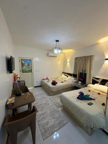 a bedroom with two beds and a table and a room at 3pyramids view inn in Cairo