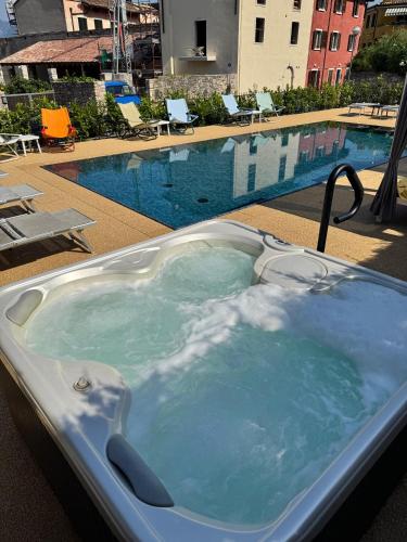 a hot tub sitting next to a swimming pool at Casa Orchidea Apartments in Torri del Benaco