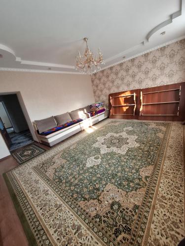 a living room with a couch and a rug at OMKA Guest House in Toktogul