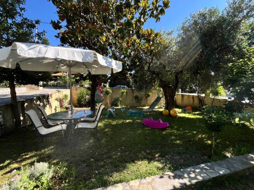 a backyard with a table and chairs and an umbrella at Studios Vasilia in Skala Potamias
