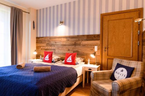 a hotel room with two beds and a chair at Ostoja Dwa Jeziora in Węgorzewo