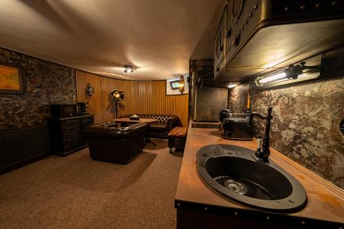 a bathroom with a sink and a living room at Pension Aperol in Hřensko