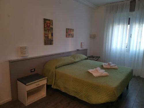 a bedroom with a bed with two towels on it at Hotel Europa in Arma di Taggia